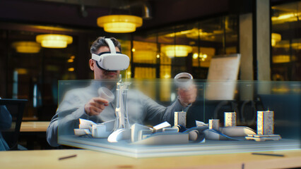 Male architect uses VR headset and wireless controllers, creates architectural project of metropolis in virtual reality. Man works in hi-tech company. 3D hologram. Future innovative AI technologies.