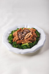braised assorted dried seafood sea cucumber mushroom bean curd skin and broccoli mixed vegetables in sauce casserole on wood table asian chinese halal food banquet menu for restaurant