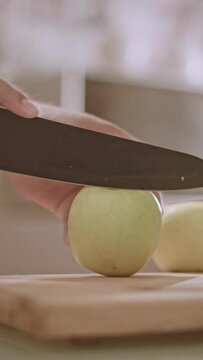 person slicing apple on table