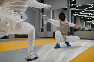 Duel of fencers during fencing match, training lesson at martial art class