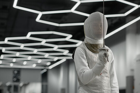 Sword sport athlete portrait wearing protective clothes and helmet at training