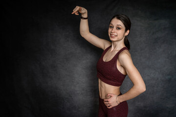 cheerful beautiful slim young woman wear sports uniform isolated on black, studio shoot