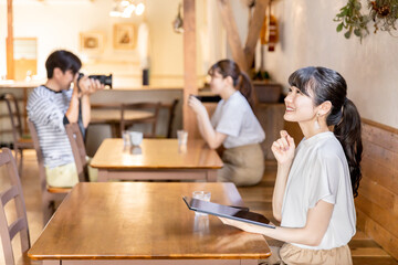 カフェ・喫茶店でタブレットを使うビジネスウーマン・クリエイターの女性
