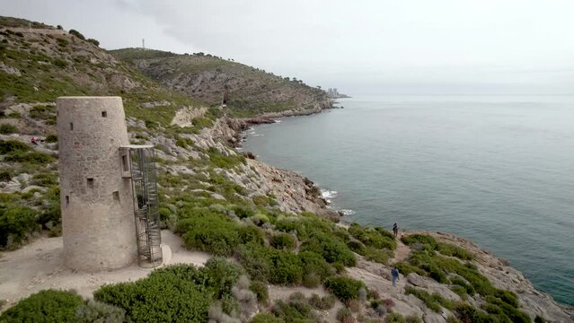 Low fly-by over a medieval tower of Mediterranean Sea coast defense in the Mediterranean Sea, Oropesa del Mar, Spain