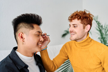 Gay man applying make up his couple at home