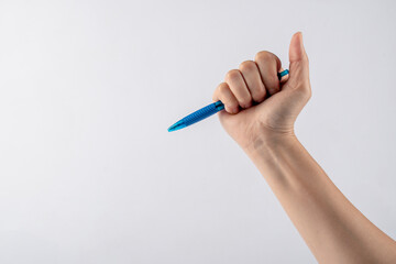 Close-up of a woman's hand holding a pen and writing gesture isolated on a white background