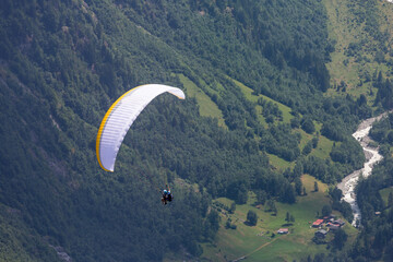Paragliding in the Swiss Alps as captured from the town of Murren, nestled below the Schilthorn mountain peak