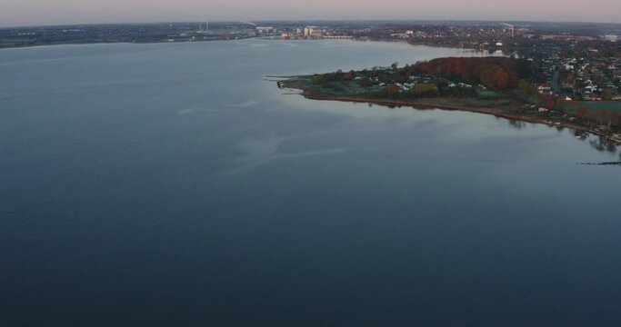 AERIAL: Drone footage of sunrise over a lake in Denmark.