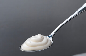 Yoghurt on silver spoon, studio shot