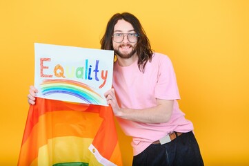 Attractive gay caucasian man holding a protest sign during a LGBT pride parade. Equality.