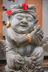 Obraz premium classic Balinese stone figure decorated with red flowers