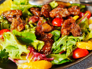 a plate of hot salad with caramelized meat.
