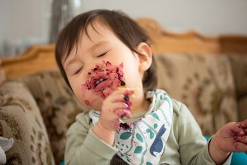 young child enjoying eating marmalade / jam / jelly
