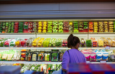 Female shopping in the supermarket for health a shopping shelf vegetable and fruit put on at food