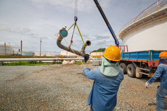 Male worker the slinger crane of the production pipeline oil and valve equipment.