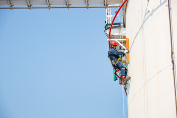 Male worker rope access inspection of thickness storage tank