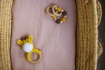 in a basket natural wooden knitted toys for a newborn. View from above - 591758551