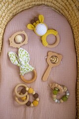 in a basket natural wooden knitted toys for a newborn. View from above - 591758564