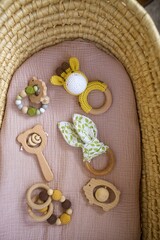 in a basket natural wooden knitted toys for a newborn. View from above - 591758578