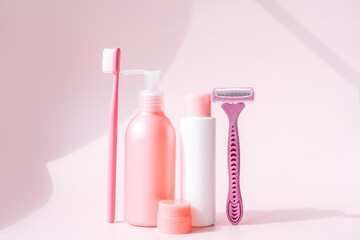 Women's hygiene and soap products in pink colors against pink background.