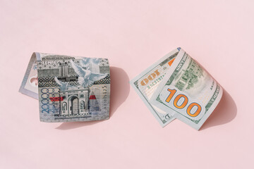 One hundred dollar bill and twenty thousand tenge on a pink background.