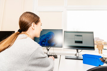 Young caucasian student learn online.coding robot car.STEM mathematics engineering science technology computer code in robotics for teenage concept.Telsiai,Lithuania 03-20-2023.