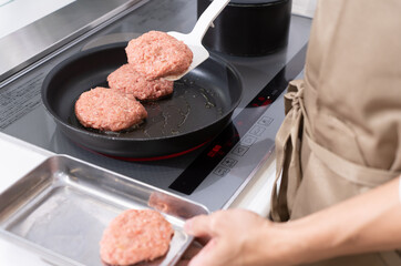 ハンバーグを焼く男性の手元