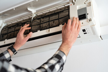 Air conditioner filter dusty. Preparation for maintenance and cleaning.