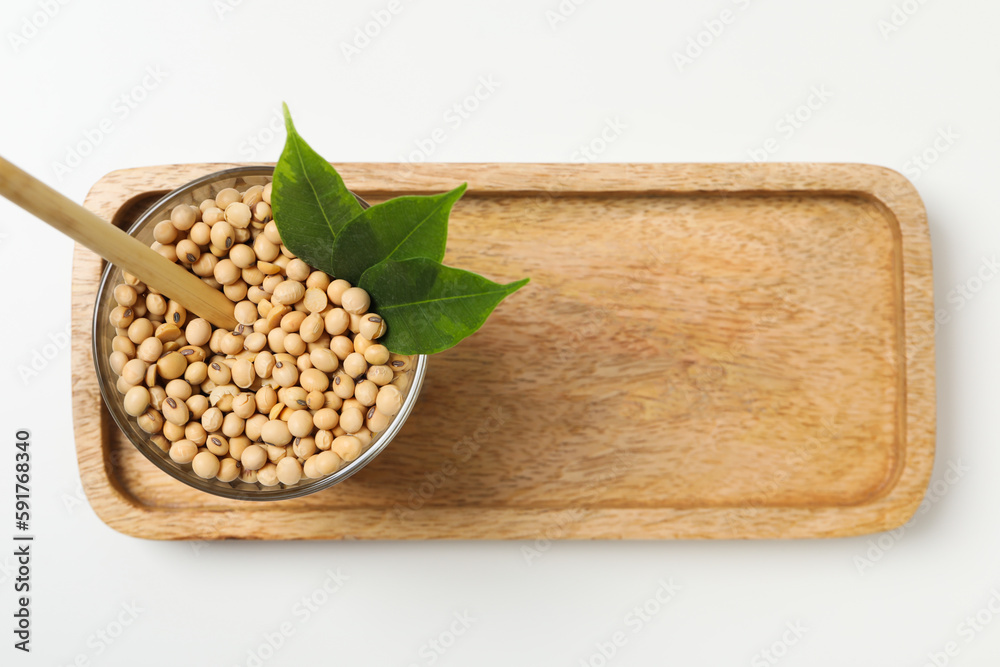 Wall mural Glass with soy seeds on white table