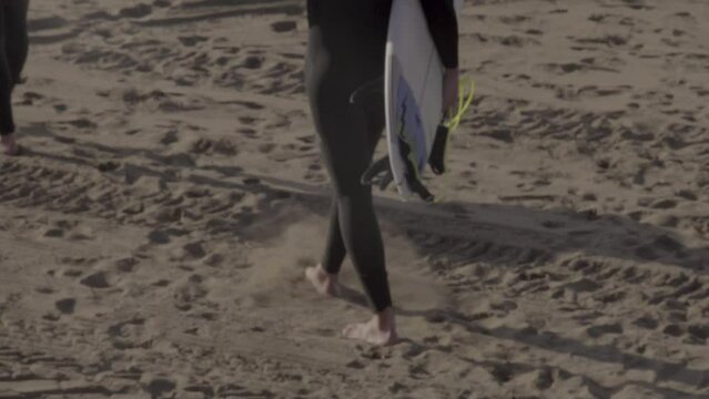 surfer walking in the sand