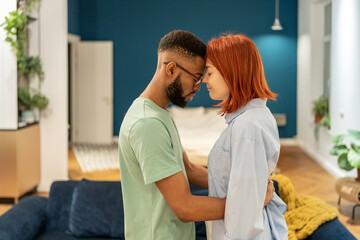 Multiracial millennial couple in love hugging embracing at home, making peace after fight. Loving black man husband supporting beloved woman wife during hard times. Support in relationships