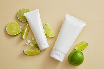 Two empty label tubes arranged with Lime slices and mini white flowers. Organic beauty product...