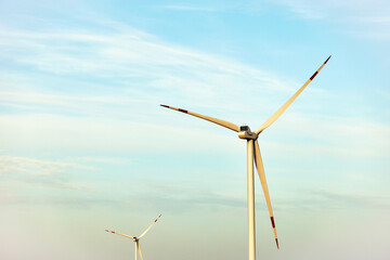 Fototapeta premium Wind turbine, alternative energy, wind energy, one windmill in a field in the mountains, top view of a wind turbine at sunset.