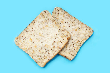 Whole grain bread slices on blue background.