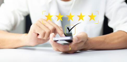 Customer pressing on smartphone with five star icon for feedback review satisfaction service	
