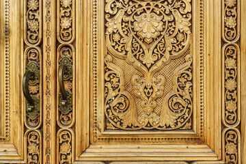 Fototapeta na wymiar Fragment of an ancient carved wooden door. Ornate.