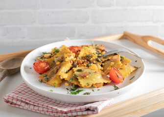 Ravioli with mushroom filling fried in butter with ham and topped with roasted pumpkin seeds and egg yolk crumbs.