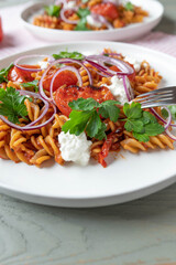Whole wheat pasta with tomato sauce, roasted tomatoes and cottage cheese, red onion topping. Healthy and low fat vegetarian dish