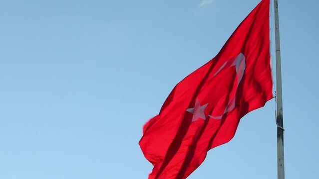 Waving Turkish Flag on blue sky background 4k video. Public holidays of Turkiye.
