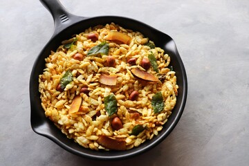 Jada Poha Namkeen Chivda or Thick Pohe Chiwda. Diwali special savory snack, made out of puffed rice, fried peanuts, curry leaves and some spices. Traditional Indian Diwali Snacks. with Copy Space.