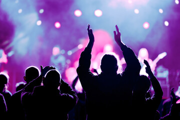 Audience and fans enjoy live music on a concert with blurry bokeh background	
