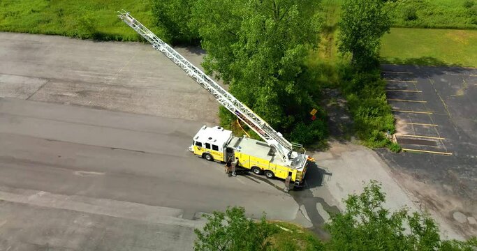 Aerial view of a fire truck with a ladder hose fully extended while running practice drills.
