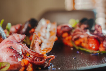 Grilled octopus with calmars, salad and lemon on plate. Close up view. © Aerial Film Studio