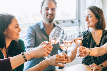 view of glasses clinking during a toast among happy people