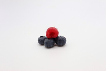 blueberries and raspberry on white background