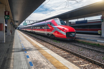 High speed train on the train station at sunny day Venice, Italy. Beautiful red modern intercity...