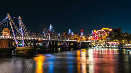 Fototapeta na wymiar Night in London, Hungerford Bridge and Golden Jubilee Bridges over River Thames, London, England