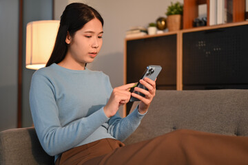 Young woman checking social media or chatting with friens on her mobile phone. People, technology and lifestyle concept