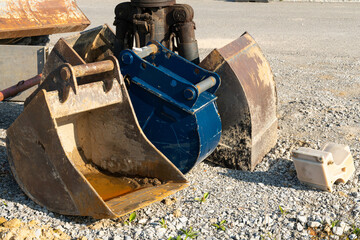 Dirty excavator buckets standing on a construction site. Close up.