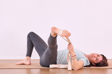 The foot being stretched with the assistance of a yoga strap during a yoga session.